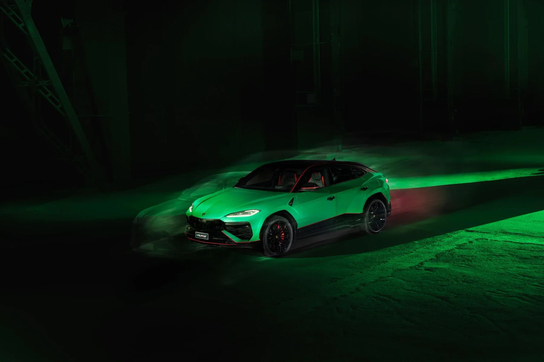 Green Lamborghini Urus SE Tettonero driving front three-quarter view