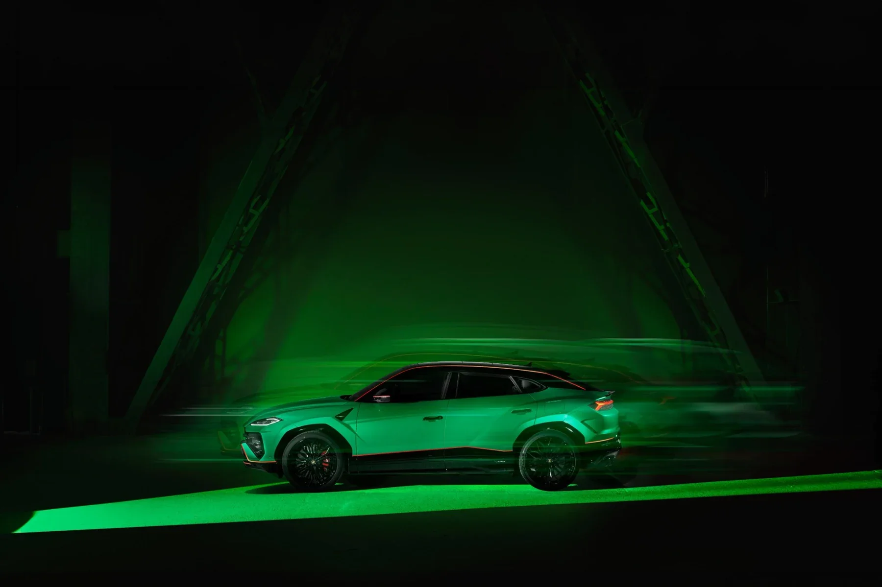 Green Lamborghini Urus SE Tettonero side profile in motion
